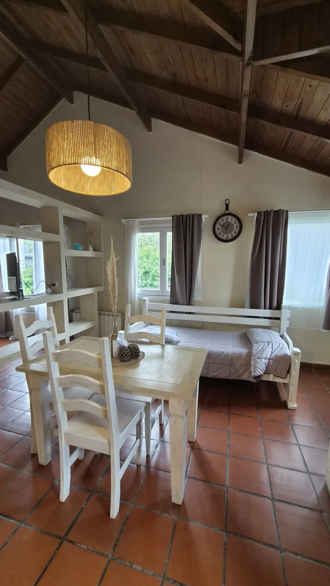 Comedor y cama del Refugio de Mar en Mar de las Pampas bajo el techo de madera a dos aguas